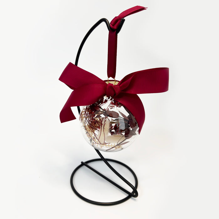 Decorative bauble with a ribbon on a white background and burgundy bow