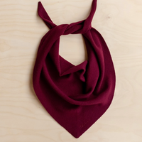 Burgundy scarf tied in a knot on a beige background