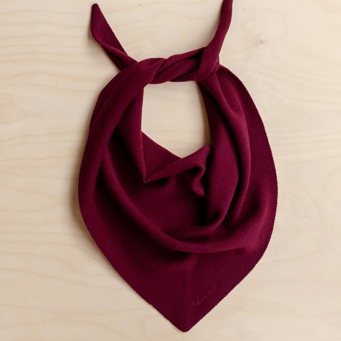 Burgundy scarf tied in a knot on a beige background