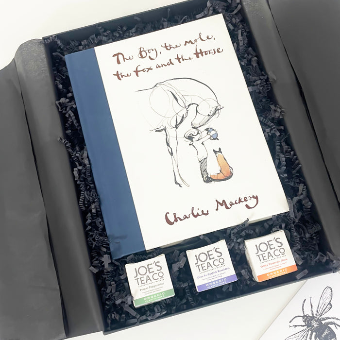 A book titled 'The Boy, the Mole, the Fox and the Horse' by Charlie Macey, presented in a black gift box with a white cover, and a set of three tea samples from Joe's Tea Co. Ltd.