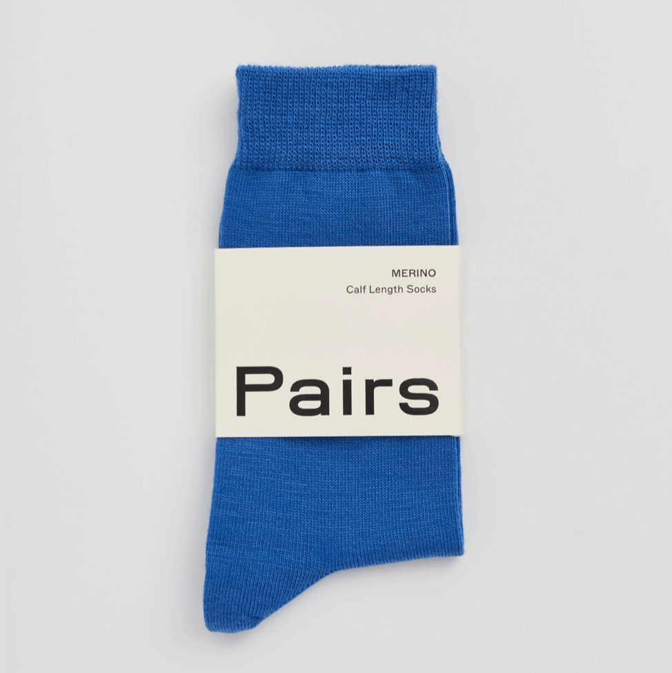Blue sock with a white label displaying 'Pairs' on a light gray background