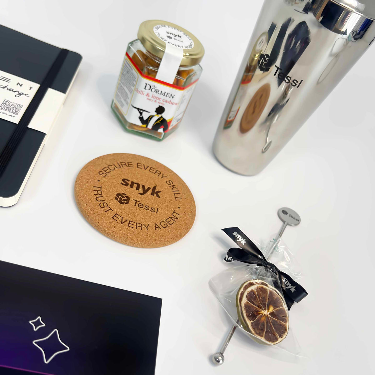 Collection of items including a phone, jar, glass, and coasters with 'snyk' branding on a white surface.