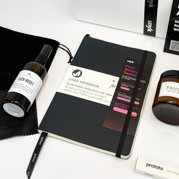 Collection of branded items including a notebook, bottle, and box on a white background