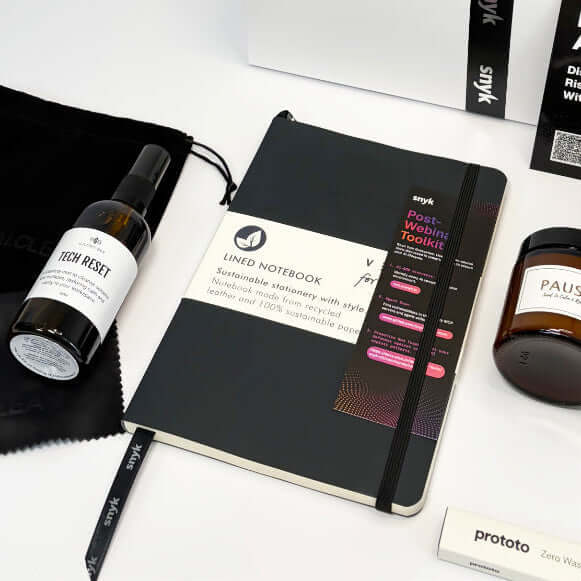 Collection of branded items including a notebook, bottle, and box on a white background