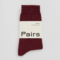 Burgundy sock with a white label on a light grey background