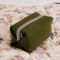 olive green wool washbag on flowery bedspread