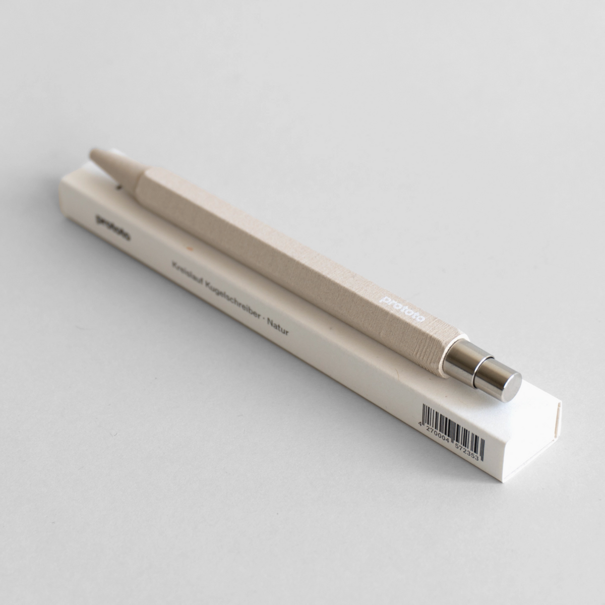Circular Ballpoint Pen on top of box with a white background