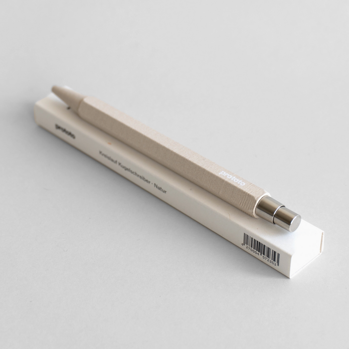 Circular Ballpoint Pen on top of box with a white background