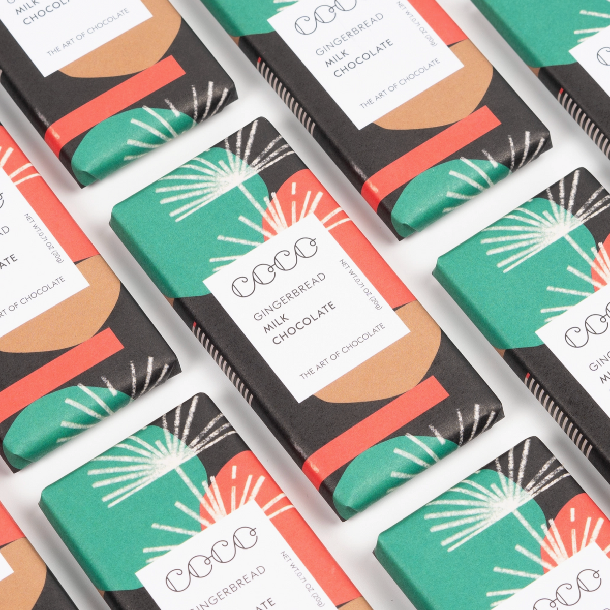 lots of Coco Gingerbread milk chocolate mini bars on white background 