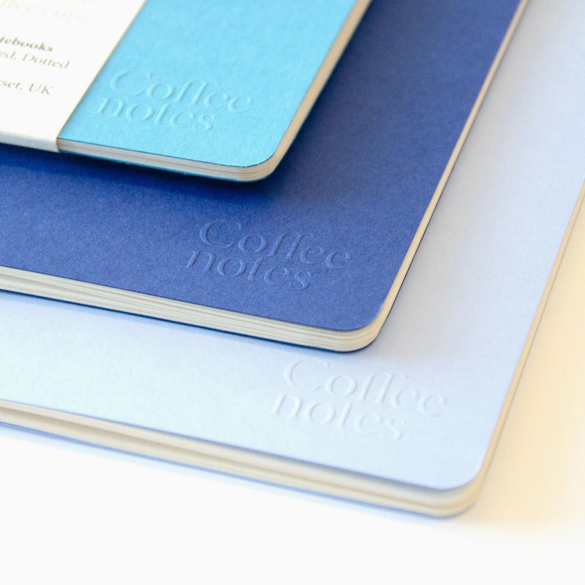Three notebooks with 'Coffee notes' text on a white background