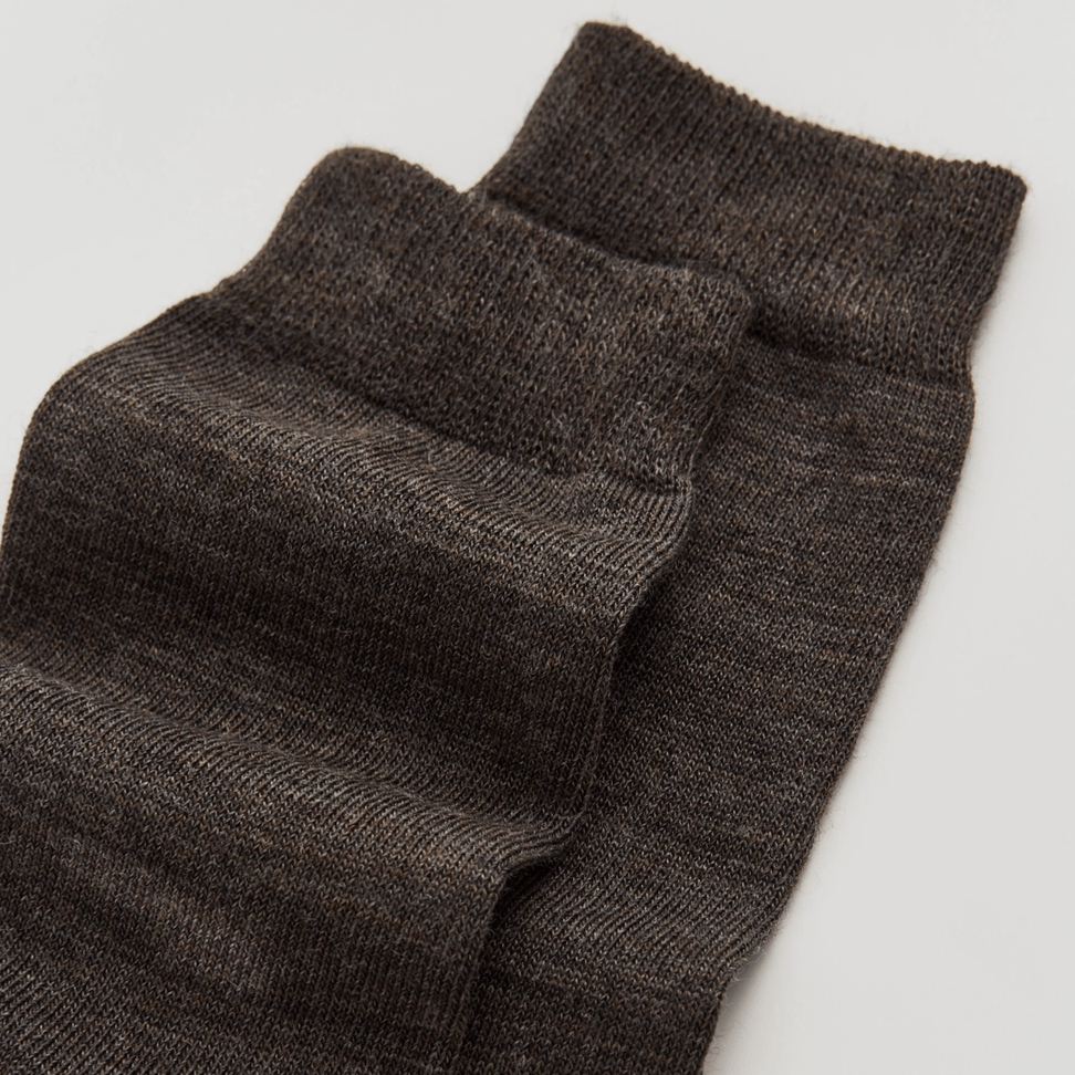 Pair of dark brown socks on a light grey background