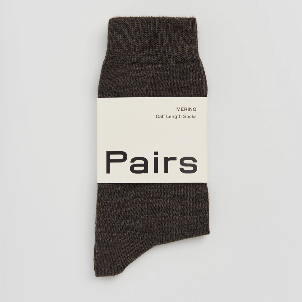Dark brown sock with a white label on a light grey background