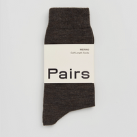 Dark brown sock with a white label on a light grey background