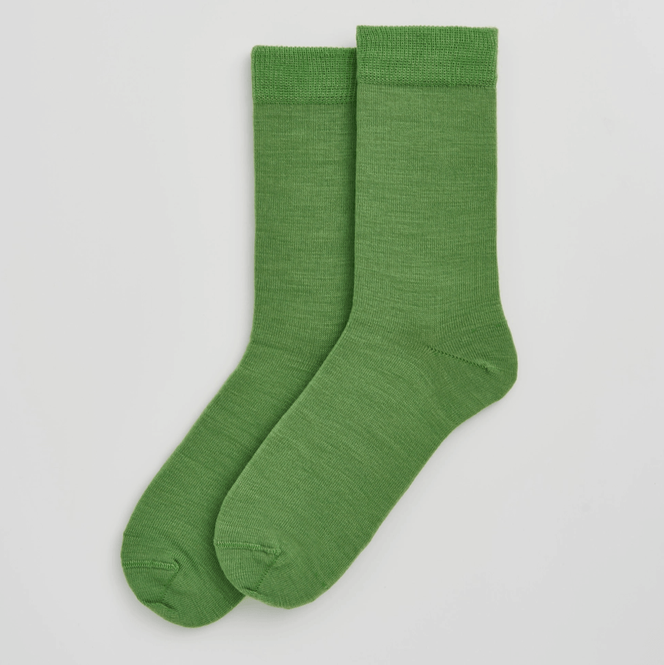 Pair of green socks on a light gray background