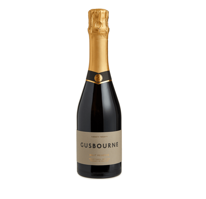 Gusbourne sparkling wine bottle with gold foil cap on a white background