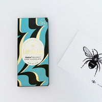 Dark chocolate bar with decorative packaging on a white background