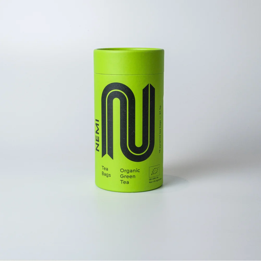 Green tube of Nemi green tea grey background 