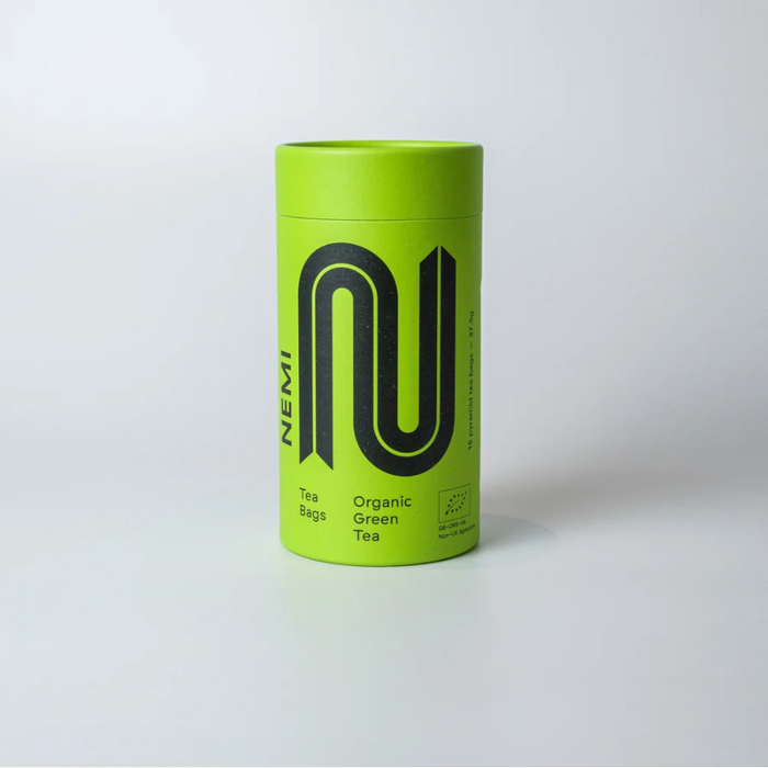 Green tube of Nemi green tea grey background 