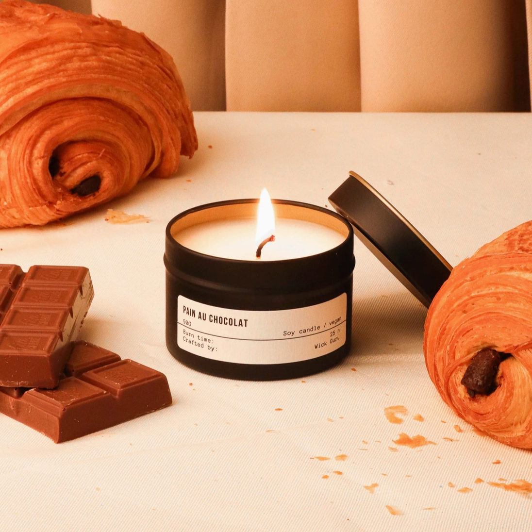 Pain Au Chocolat Candle by Wick Guru with chocolate in the background