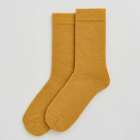 Pair of mustard yellow socks on a light gray background