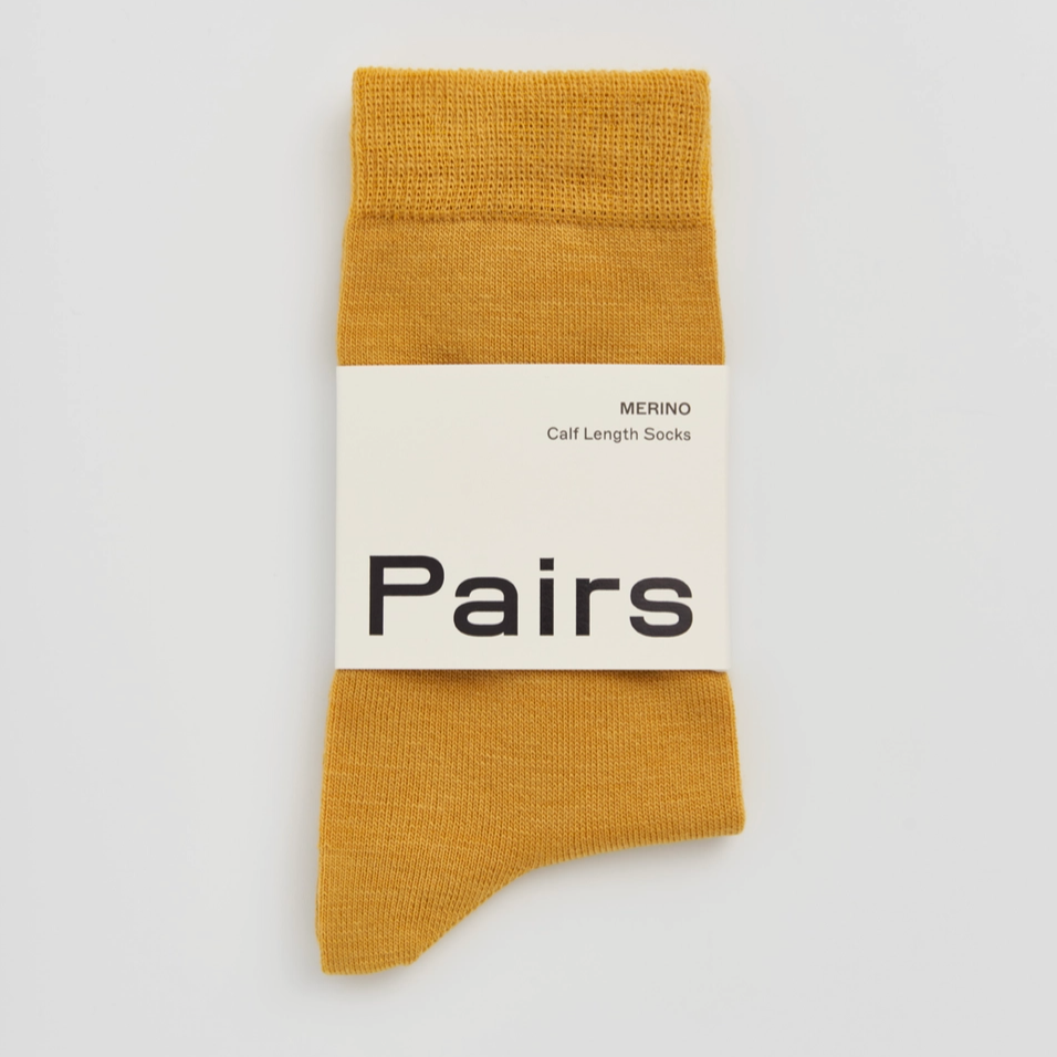Mustard Warm yellow merino wool mens socks with pairs label on grey background 