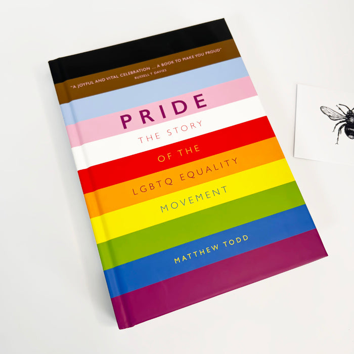 Book titled 'Pride: The Story of the LGBTQ Equality Movement' with rainbow cover on a white background