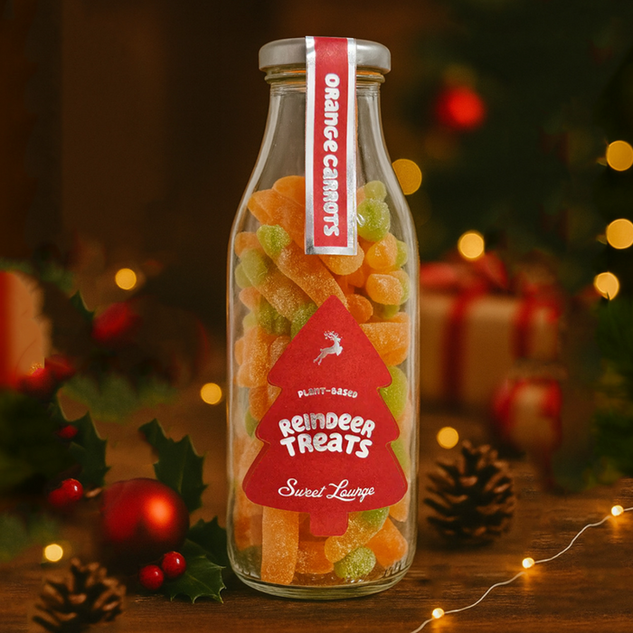 Glass bottle of reindeer treats with Christmas decorations in the background