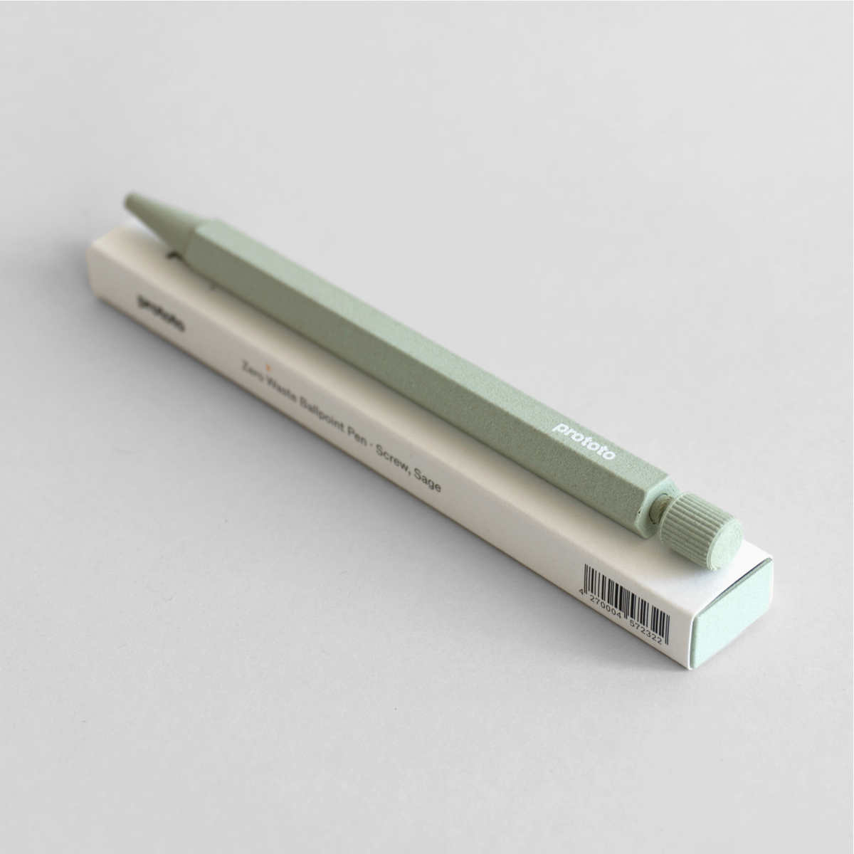 Green pen and its packaging on a light gray background
