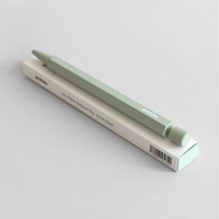 Green pen and its packaging on a light gray background