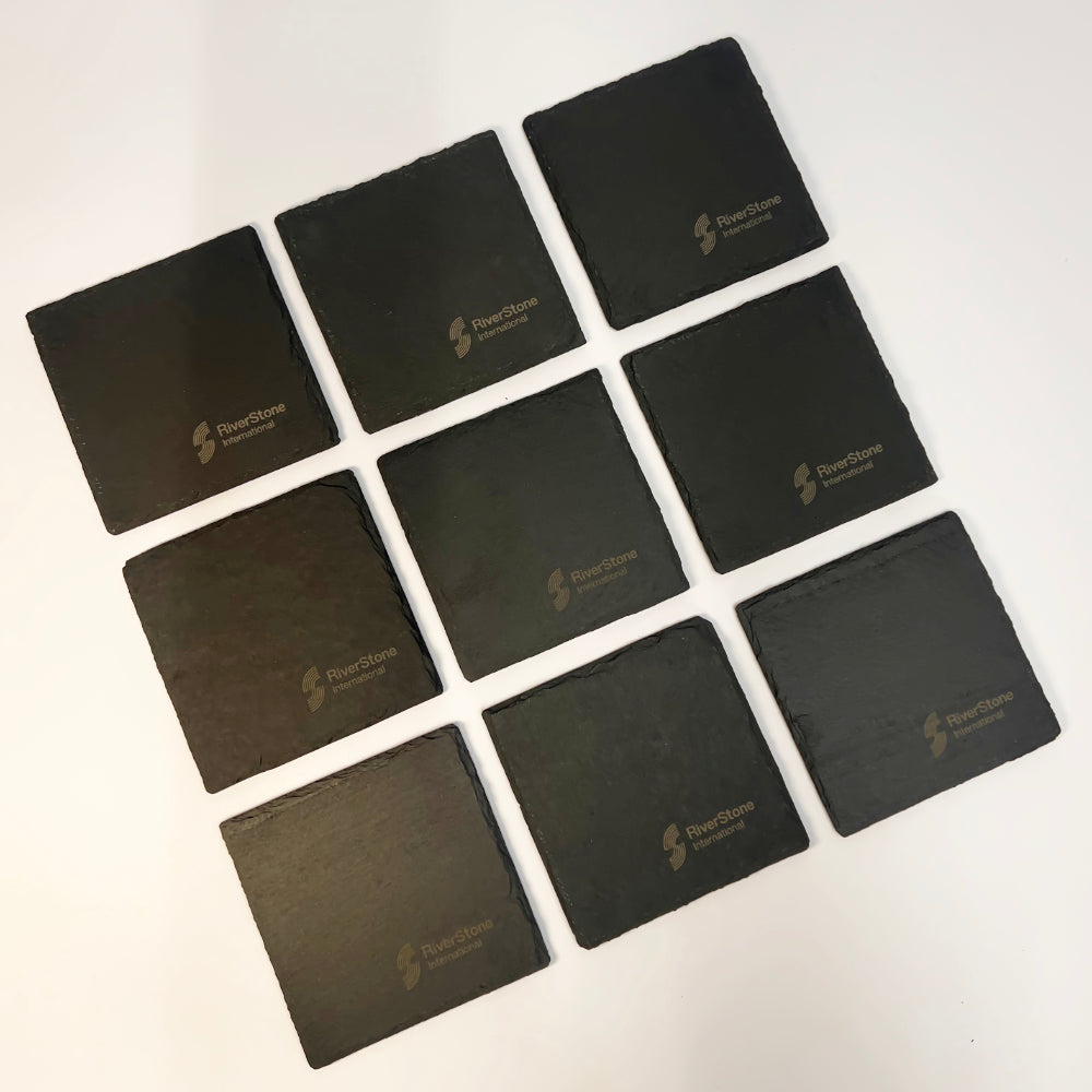 Nine square black slate coasters arranged in a 3x3 grid on a white background. Each coaster features a debossed logo for 'FourStone Bar & Grill' in a light metallic color.