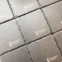 Grey slate coaster arranged in a grid pattern, showing a textured stone surface with visible RiverStone International watermarks.