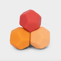 Three hexagonal silicone containers in red, orange, and light peach, stacked together on a light gray background.