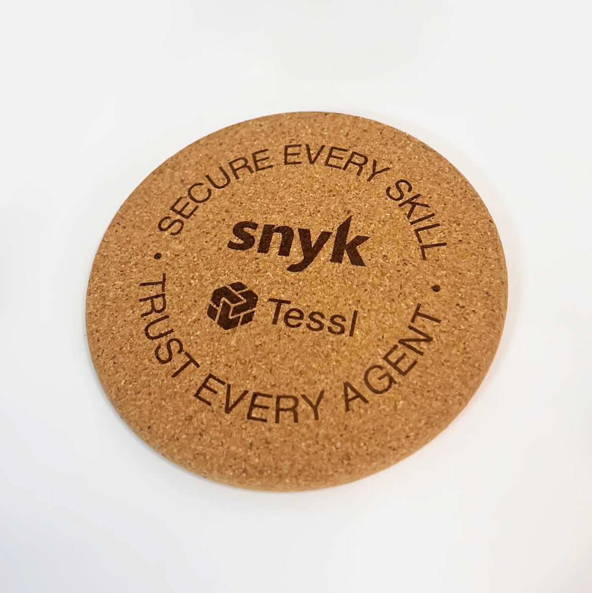 Round cork coaster with 'snyk' and 'Tessl' branding on a white background