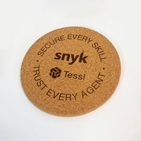 Round cork coaster with 'snyk' and 'Tessl' branding on a white background
