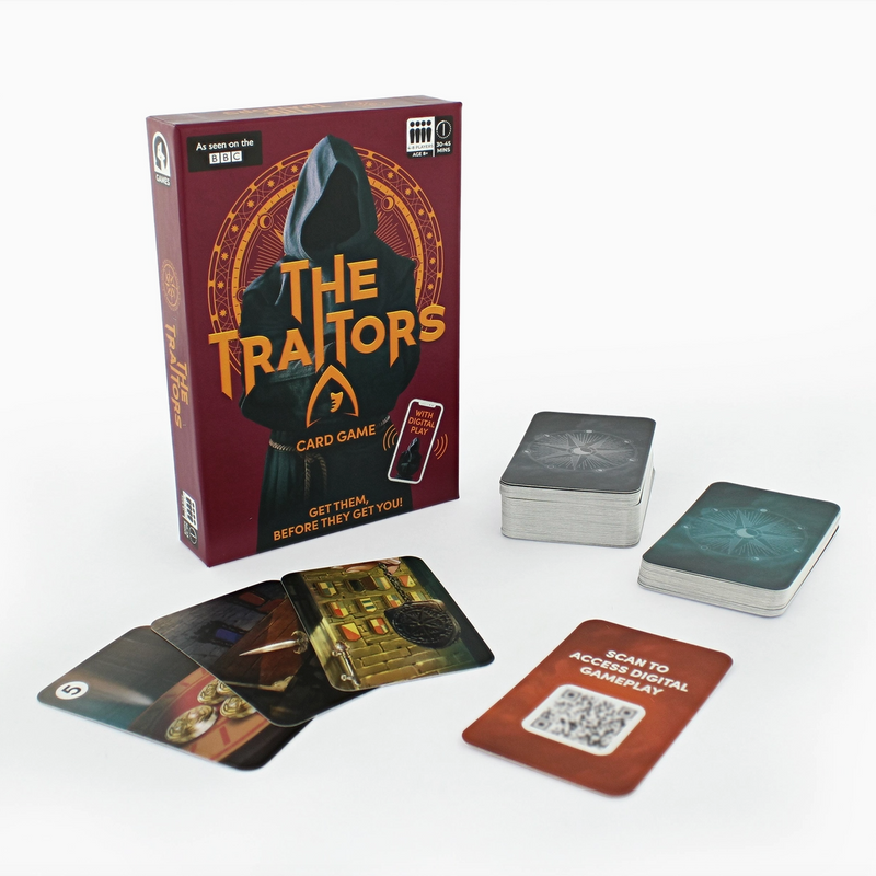 The Traitors card game set displayed on a clean white background, including the main box, two decks of cards, and several sample cards laid out in front.