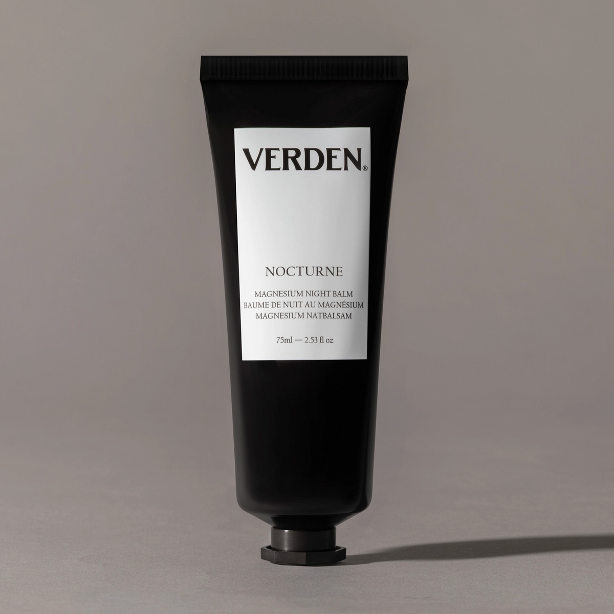 Black tube of Verden Nocturne balm on a gray background