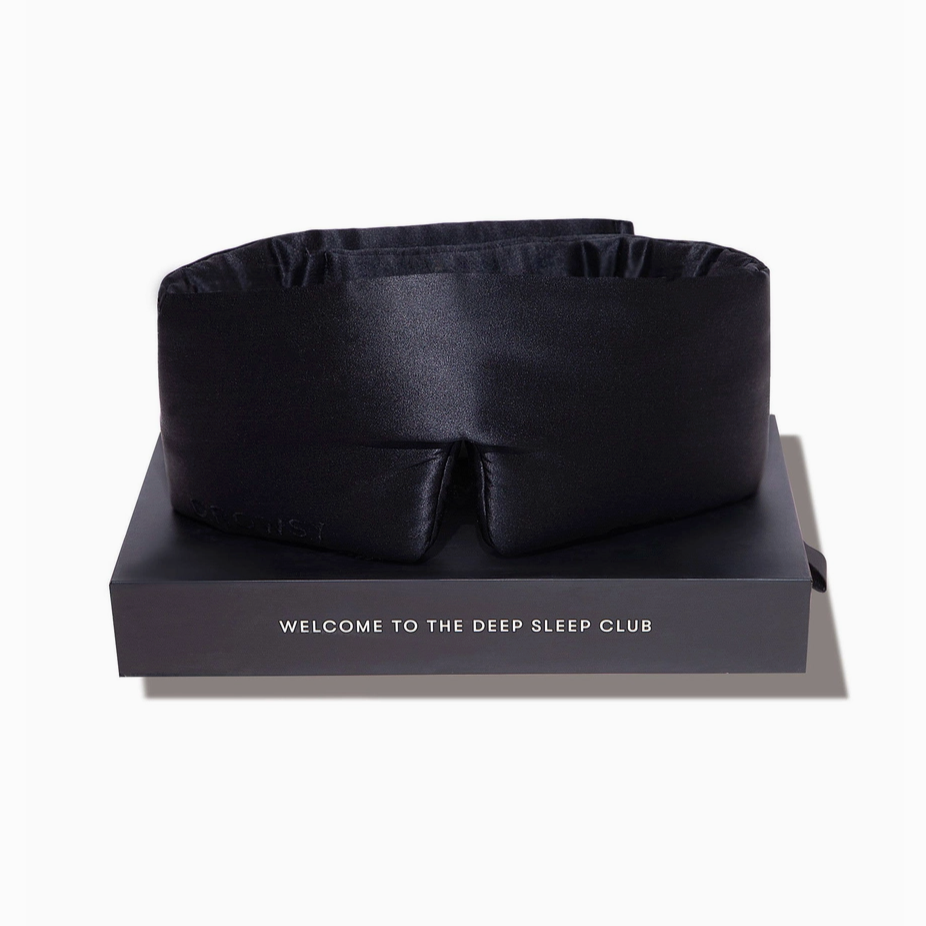 Black satin eye mask on a branded box with 'Welcome to the Deep Sleep Club' text.