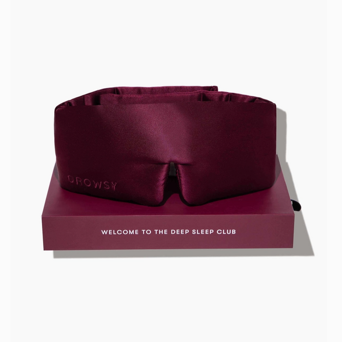 Maroon sleep mask on a matching box with 'drowsy' branding and text on a white background