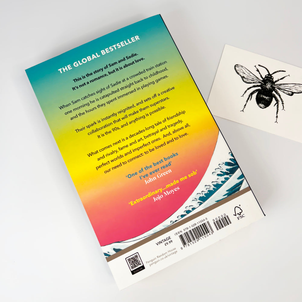 Back of tomorrow and tomorrow and tomorrow book cover with a gradient design and text, featuring a bee illustration on a card.