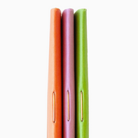 Three colourful notebooks in orange, pink, and green on a white background